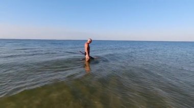 Bir adam ev yapımı mızrak ve ağ kullanarak Karadeniz 'i sığ sularda avlıyor..