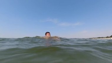 Baba oğlunu kustu ve deniz suyuna daldı. Ağır çekim. Aile deniz tatili, su oyunları.