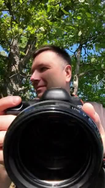 Чоловік Фотоапаратом Пробивається Крізь Дерева Щоб Отримати Кілька Пострілів Вид — стокове відео
