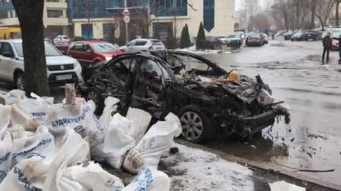 Kyiv, Ukrayna - 5 Ocak 2024: Rusya 'nın 2 Ocak 2024 sabahı erken saatlerde Kyiv' e gerçekleştirdiği ağır bir füze saldırısı sonucu yıkılan bir evin yakınına park edilmiş hasarlı bir araba.