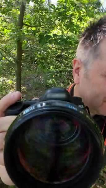 Чоловік Фотоапаратом Пробивається Крізь Дерева Щоб Отримати Кілька Пострілів Вид — стокове відео