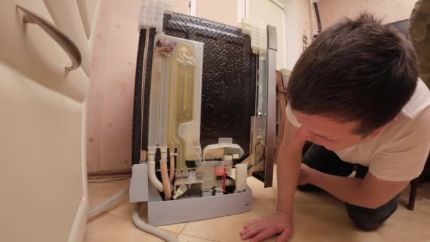 Чоловік Ремонтує Свою Посудомийну Машину Він Оглядає Посудомийну Машину Витоку — стокове відео