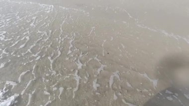 Deniz sörfü. Dalgalar deniz kıyısındaki kumlara vuruyor. Yavaş çekim. 
