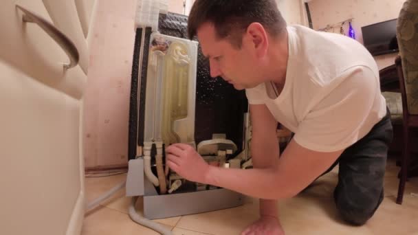 一个人修理自己的洗碗机 他检查洗碗机的软管接头 — 图库视频影像