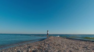 Yaz sabahının erken saatlerinde Kinburn Split 'in kenarında bir adam duruyor. Sağda Dinyeper-Buzhsky Estuary 'nin tatlı suyu, solda Karadeniz' in tuzlu suyu var.