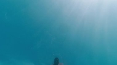 Gözlüklü adam denizin derinliklerine dalıyor.