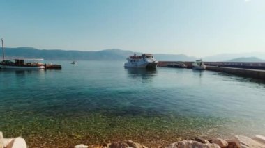 Slatine, Hırvatistan - 15 Ağustos 2021: Bura Hattı feribotu yolcularla birlikte yaz sabahının erken saatlerinde rıhtımdan ayrılıyor.