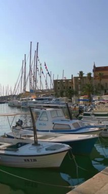 Güneşli bir yaz gününde marinada bir sürü yat ve tekne var. Hırvatistan 'daki adalardan birinin limanı. Çevir. Dikey Video