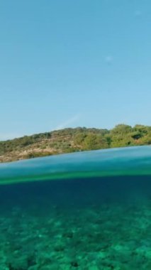 Güneşli bir yaz gününde Adriyatik Denizi 'nde pitoresk bir ada. Dikey Video