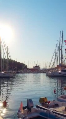 Güneşli bir yaz gününde marinada bir sürü yat ve tekne var. Hırvatistan 'daki adalardan birinin limanı. Dikey Video