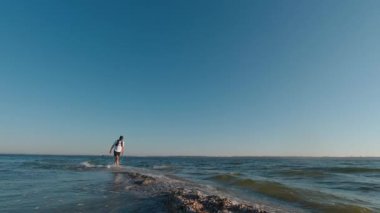 Adam sabahın erken saatlerinde Ukrayna 'da Kinburn Spit' in kenarında yürüyor. Sağda Dinyeper-Buzhsky Estuary 'nin tatlı suyu, solda Karadeniz' in tuzlu suyu var..