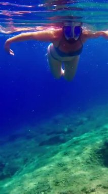 Adriyatik Denizi 'nde dalış yapan bir kadın. Su altı görüntüsü. Dikey Video