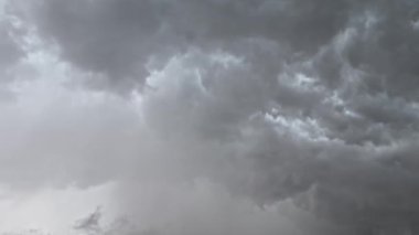 Bulutlardaki gri bulutlar ara sıra yıldırımlarla aydınlanır.
