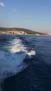 Güneşli bir yaz sabahında sürat teknesinin bıraktığı suda bir iz. Dikey Video