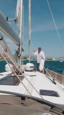 Bir adam limana girmeden önce bir yata çamurluk takıyor. Dikey Video