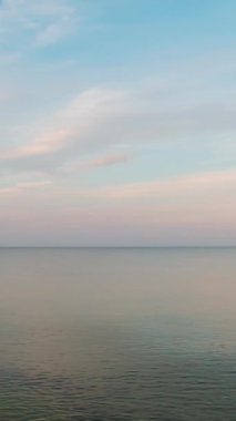 Sabahın erken saatlerinde deniz manzarası. Denizde tam bir sakinlik. Çevir. Dikey Video