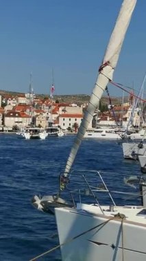 Güneşli yaz gününde marinada bir sürü yat ve tekne var. Hırvatistan 'daki bir adanın limanı. Dikey Video