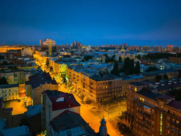 Gece boyunca Kyiv 'in manzarası, sokakları aydınlatan ışıklar ve tepemizde mavi bir gökyüzü.