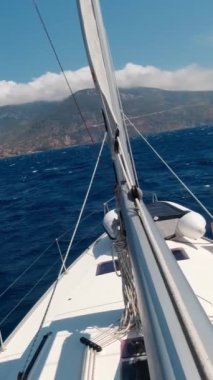 Güneşli bir yaz gününde yelkenli ile bir yatta deniz maceraları. Tatil ve yaz tatili konsepti. Dikey Video