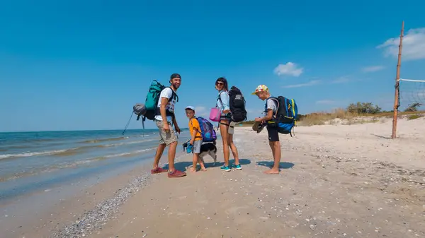 Mükemmel bir yaz günü, bu dört kişilik aileyi ve köpeklerini kumlu sahil boyunca yürüyüşe çıkmaya hazır olarak bulur.