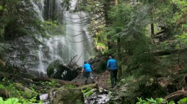 Turistler çölün ortasındaki güçlü bir şelaleye, etrafındaki dallara ve engebeli araziye hayret ediyorlar.