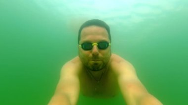 Su altında Yüzme: Gözlüklü Adam Güneşli Tatilde Denizin Tadını Çıkartıyor