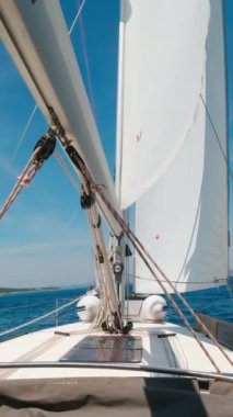 Güneşli bir yaz gününde yelken altında bir yatın pruvası. Dikey Video