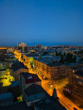 Akşamları Kyiv 'in panoramik manzarası aydınlık sokaklar ve mavi bir gökyüzü.