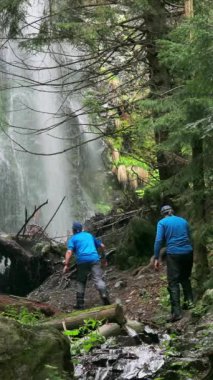 Turistler çölün ortasındaki güçlü bir şelaleye, etrafındaki dallara ve engebeli araziye hayret ediyorlar.