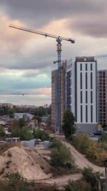 Akşamları hareketli bir inşaat sahası canlanıyor ve bulutlar hızla üstümüzden geçerken turnalar kentsel gelişimin dinamik atmosferini gösteriyor. Dikey Video
