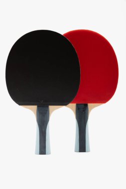 Çift profesyonel ping pong raketleri zıt siyah ve kırmızı kauçuk yüzeyler eşleşen ergonomik kulplar, stüdyo ışıklandırmasında simetrik olarak düzenlenmiştir