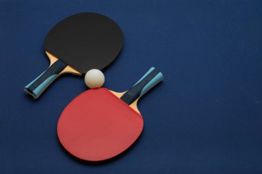 Siyah ve kırmızı kauçuk yüzeyli birinci sınıf masa tenisi raketleri profesyonel spor ekipmanları sergisi için derin donanma arka planında düzenlenmiştir.