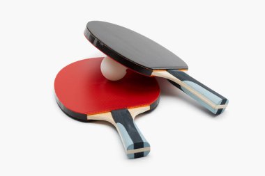 Dinamik açılara yerleştirilmiş zıt siyah ve kırmızı raketler içeren profesyonel ping pong ekipmanları, rekabetçi düzeyde beyaz top sanatsal gerilim yaratıyor