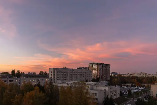 Gün batımı bulutlarından oluşan canlı bir sıra şehrin her tarafına yayılıyor ve alacakaranlık yaklaşırken sonbahar atmosferini güçlendiriyor.