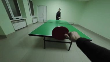 Otantik masa tenisi oyunu, birinci şahıs perspektifinden gerçek zamanlı olarak çekildi, dinamik raket hareketlerini ve yoğun mitingleri iyi ışıklandırılmış kapalı mekandaki profesyonel yeşil masa üzerinde gösteriyor.