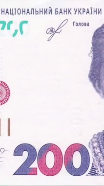 Ukrayna 'nın 200 Hryvnia banknotunun, pembe-mor renk şemasında holografik çizgiler ve koruyucu desenler içeren, banknot sayısı ve güvenlik unsurlarına odaklanan yakın görüntüsü