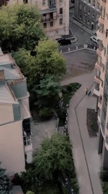 Günbatımında nefes kesen şehir manzarasında modern ve tarihi binaların bir karışımı yer alıyor. Ufuk çizgisinde bir televizyon kulesi ve batan güneş Kyiv, Ukrayna 'dan gelen sıcak turuncu ışıkla yıkanan yüksek katlı daireler yer alıyor. Dikey Video