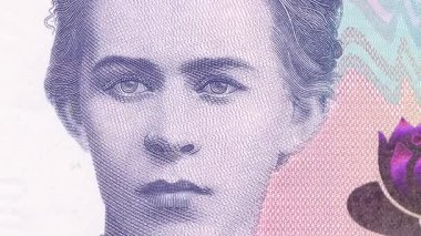Ukraynalı şair Lesya Ukrayna 'nın ayrıntılı portresinden 200 Hryvnia banknot görüntüsünü tamamlamak için dinamik zumlama, nilüfer çiçeği amblemi ve pembe-mor tonlarda koruyucu unsurlar içerir