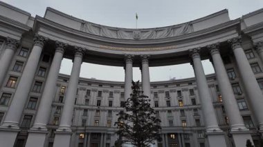 Kyiv 'deki neoklasik Dışişleri Bakanlığı binası büyük sütunları ve bulutlu kış gökyüzünün altında bir Noel ağacı ile dimdik ayakta duruyor.