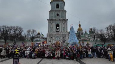 Kyiv, Ukrayna - 25 Aralık 2024: Kyiv 'deki Aziz Sophia Katedrali önünde bulutlu bir kış gününde mavi bir Noel ağacı yakınında büyük bir kalabalık toplandı.