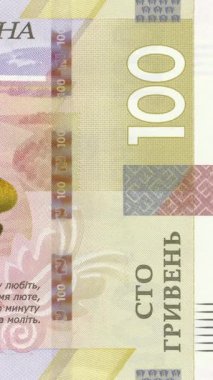 100 UAH banknotunun sağ tarafında güvenlik unsurları, belirgin sayısal tasarım, Shevchenko alıntısı ve ulusal para biriminde kendine özgü koruyucu modeller içeren dikey ayrıntılı bir görünüm