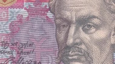 Hetman Ivan Mazepa 'nın detaylı portresini içeren Ukrayna 10 Hryvnia banknotunun dinamik görünümü, koruyucu unsurlar ve ulusal sembollerle yüz yakın planından tam not görünümüne geçiş