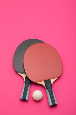 Karşıt kırmızı ve siyah yüzeyli profesyonel pinpon raketlerinin zarif kompozisyonu, derin donanma arka planına karşı sergileniyor.