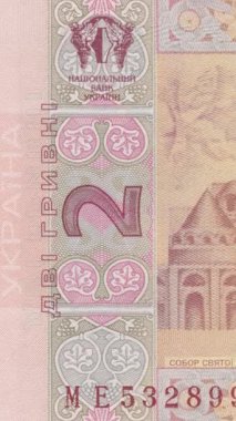 Dikey video, karmaşık güvenlik modellerine ve otantik Ukrayna banknotunun koruyucu unsurlarına pembe tonlarda dekoratif tasarımları detaylı bir şekilde gösteren yavaş zoom gösteriyor.