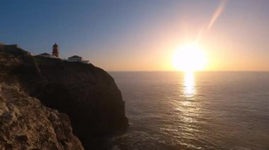 Atlantik Okyanusu üzerinde nefes kesen altın günbatımı Cabo de So Vicente deniz feneri, Portekiz 'in güneybatı kıyısında kayalıkların birleştiği yerde gün ışığından alacakaranlık mavisine geçerken dramatik manzaralar yaratıyor.