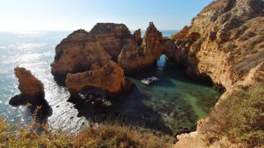 Portekiz 'in Lagos yakınlarındaki Ponta da Piedade' de büyüleyici altın kireçtaşı kemeri, Algarve 'nin sahil şeridindeki kristal berrak sulardan oluşan bir turkuaz koyunu çevreleyen dramatik uçurumlar.