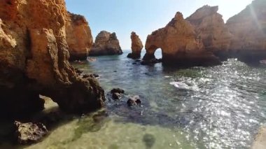 Portekiz, Lagos yakınlarındaki Ponta da Piedade 'deki ikonik altın kireçtaşı kemerlerinin ve kaya oluşumlarının nefes kesen manzarası, burada dramatik aşınmış uçurumlar Atlantik Okyanusu' nun kristal berrak turkuaz sularıyla buluşuyor.