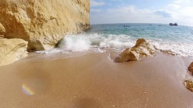 Büyüleyici yavaş çekim görüntüleri, kıyı kayalarıyla çarpışan güçlü okyanus dalgalarını yakalar. Turkuaz suların arka planına ve berrak mavi gökyüzüne çarpan beyaz sprey ve köpük patlamaları yaratır.