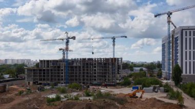 Değişen bulut oluşumlarına karşı çalışan mavi kule vinçleriyle dinamik zaman ayarlı apartman kompleksi inşaatı, kentsel gelişim ve inşaat teknolojisini eylem halinde gösteren