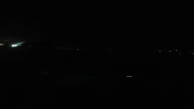 Aydınlanmış Lizbon şehir ışıkları üzerinden gece kalkış yapan uçak.